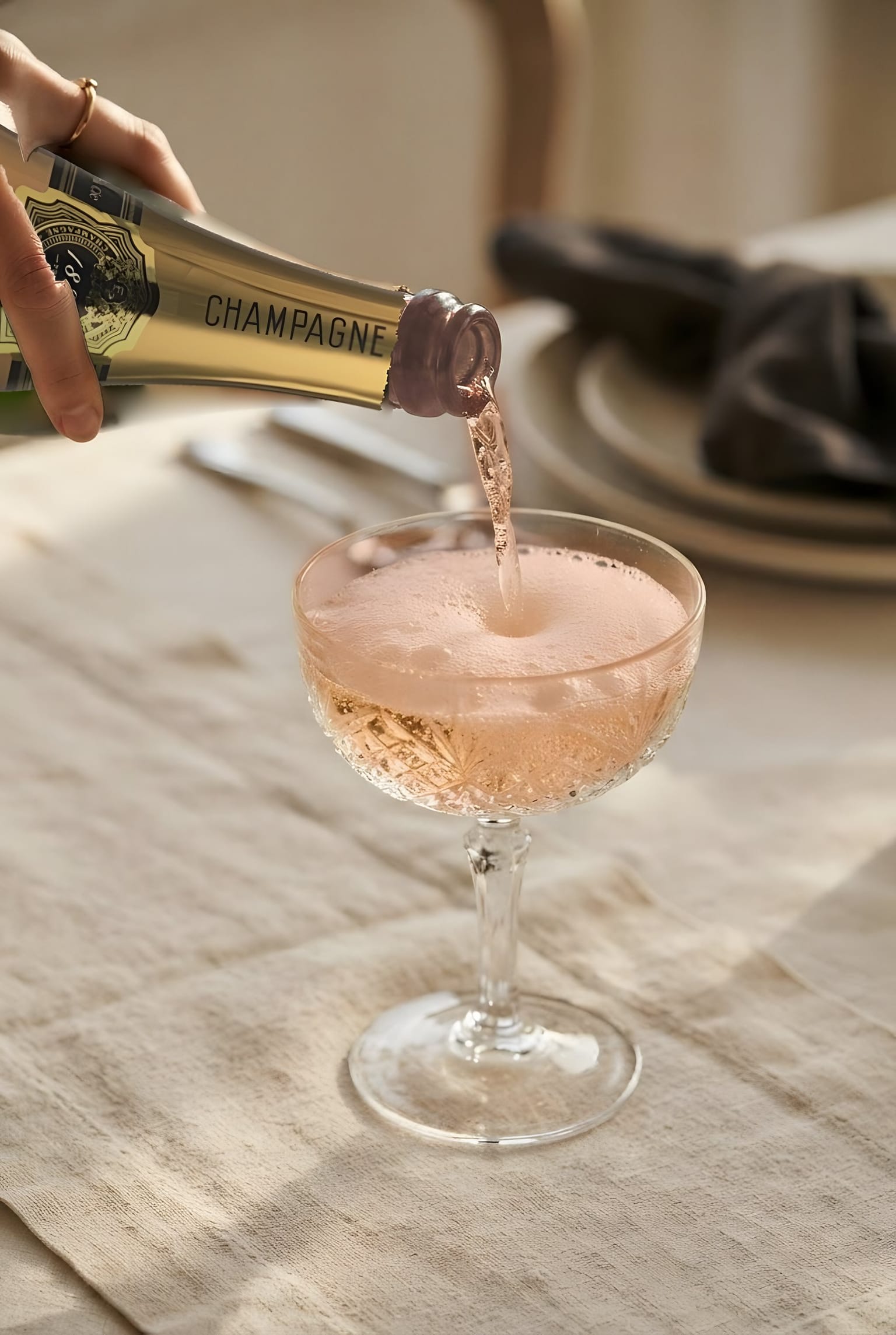 Champagne versé dans une coupe, sur une nappe de lin