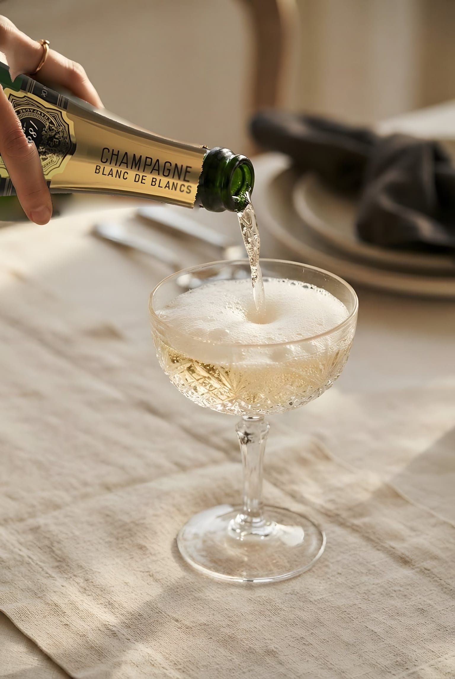 Champagne versé dans une coupe, sur une nappe de lin